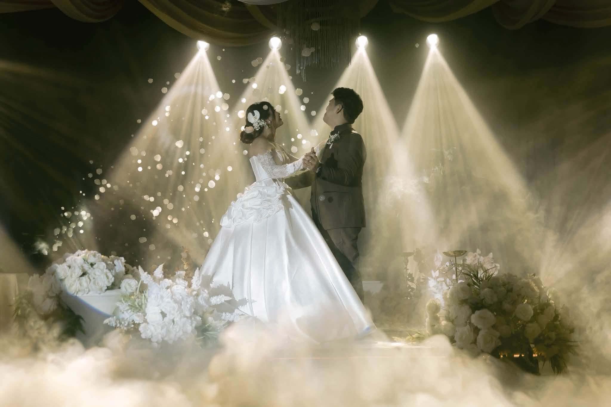 A first dance under four spotlights and drifting fog