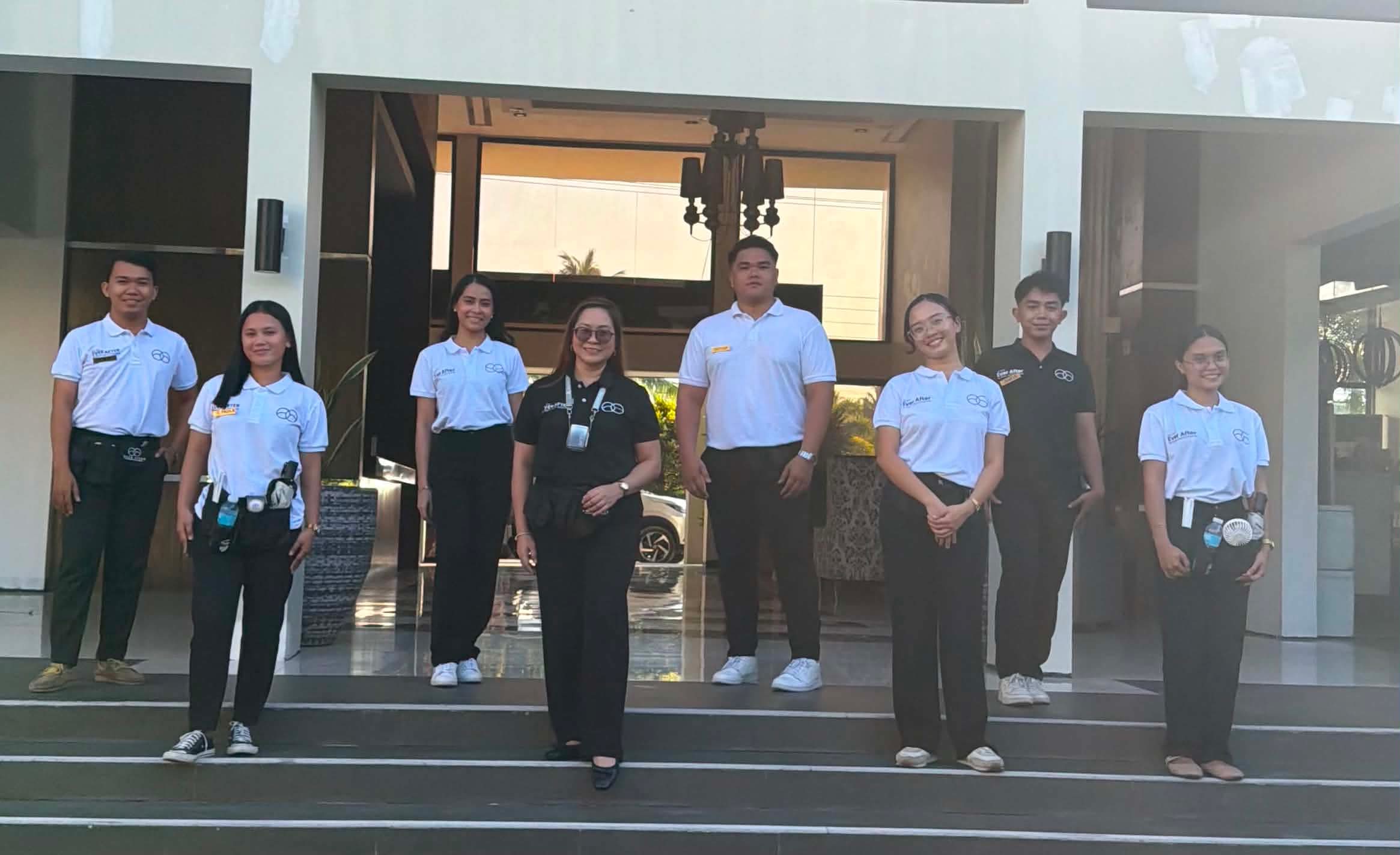 The Ever After team of eight in branded polos on the steps of a venue entrance, Sharon at the centre